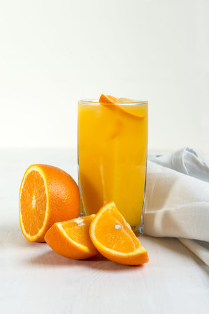 Glass of orange juice and orange piecesの写真素材