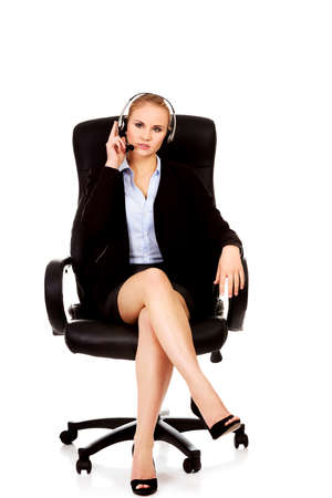 Young woman helpline operator is trying to hear something headphonesの写真素材