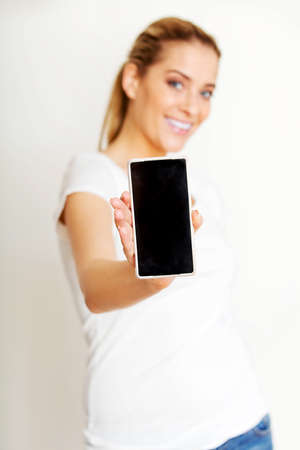 Happy woman showing a smart phoneの写真素材