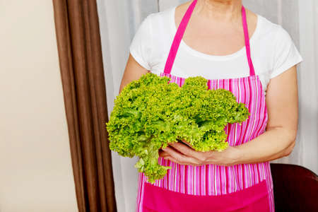 Senior woman holding green saladの写真素材