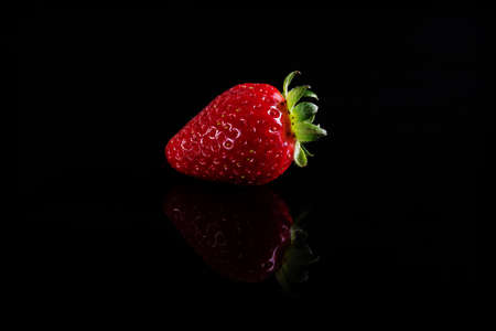 One juicy strawberry on black background.の写真素材