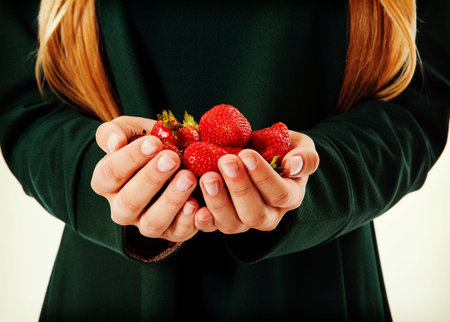 Woman holding strawberry on open palms.
