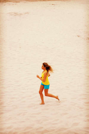 Young woman running on the beach.の写真素材
