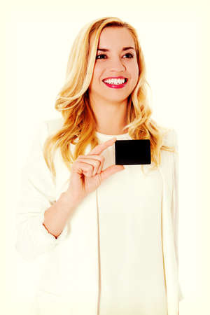 Happy smiling business woman showing business card, isolated over white backround.の写真素材