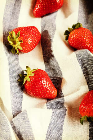Five juicy strawberry on kitchen cloth.の写真素材