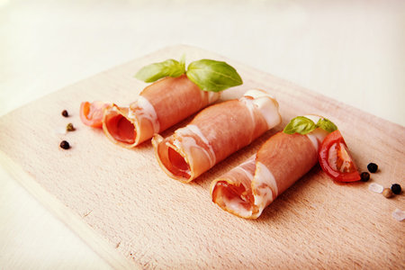 Black forest ham on wooden cutting board.の写真素材