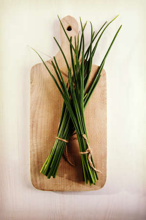 Fresh green chives on cutting board.の写真素材