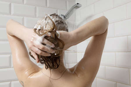 Beautiful naked young woman taking shower in bathroomの写真素材