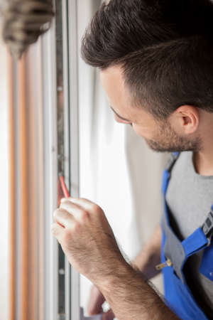 Young handyman repair windowの写真素材