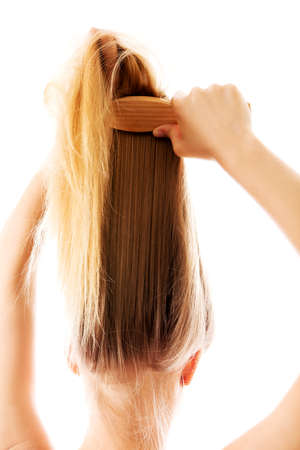 Girl with long and straight hair combing herself.の写真素材