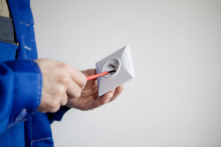 Electrician hands with screwdriver fixing socket. Repair of electricity conceptの写真素材