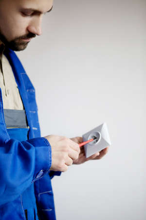 Electrician hands with screwdriver fixing socket. Repair of electricity conceptの写真素材