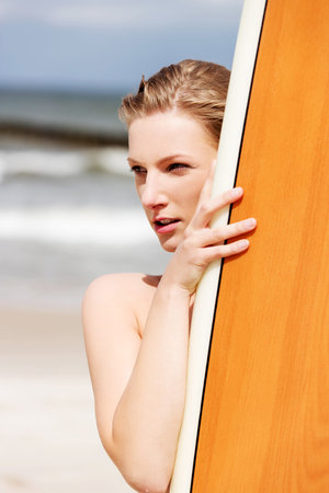 Surfer girl on the beach in bikini.