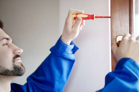 Young handyman repair window with screwdriverの写真素材