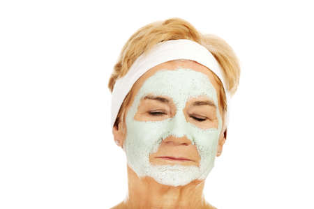 Relaxed elderly woman in facial maskの写真素材
