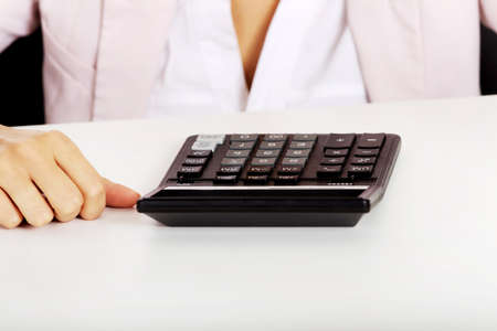Close-up photo of female sitting behind the desk with calculatorの写真素材