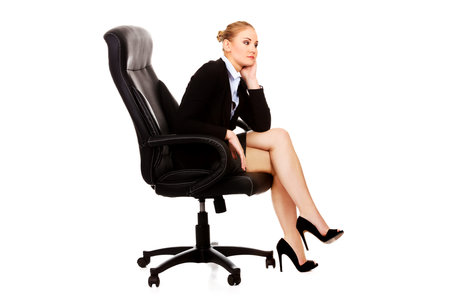 Tired or worried business woman sitting on armchairの写真素材