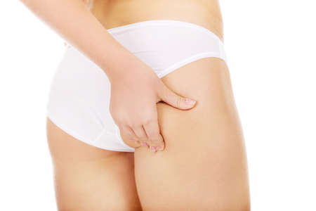 Slim young woman pinching her buttocksの写真素材