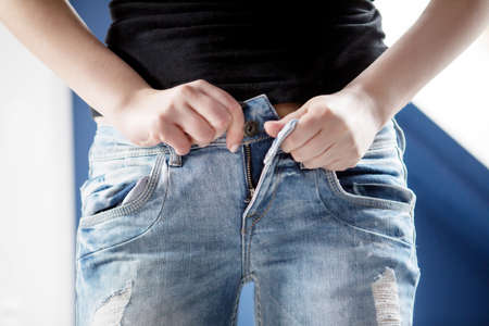 Woman pulling on tight jeansの写真素材