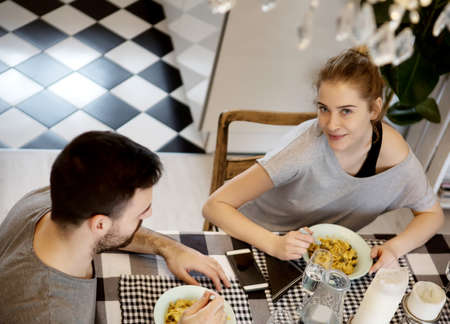Young couple sitting at the table and eating dinnerの写真素材