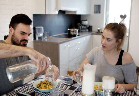 Young couple sitting at the table and eating dinnerの写真素材