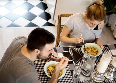 Young couple sitting at the table and eating dinnerの写真素材