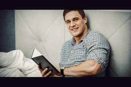 Thoughtful man with a note in his bed.の写真素材