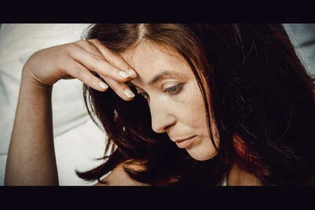 Sad depressed woman on bed.の写真素材