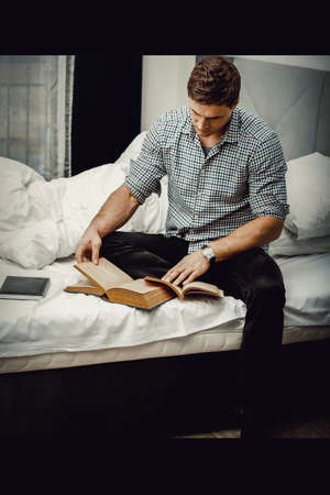 Man reading a book in his bed.の写真素材