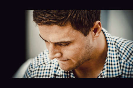 Handsome young adult man in bedroom.の写真素材