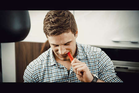 Handsome man eating carrot.の写真素材