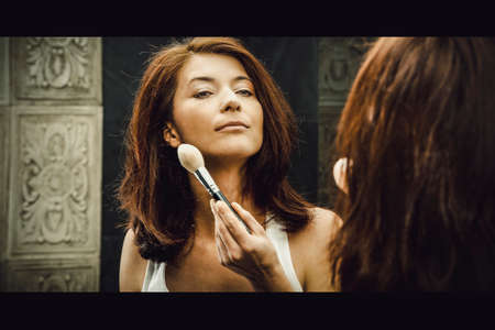 Beautiful woman brushing her cheek.の写真素材