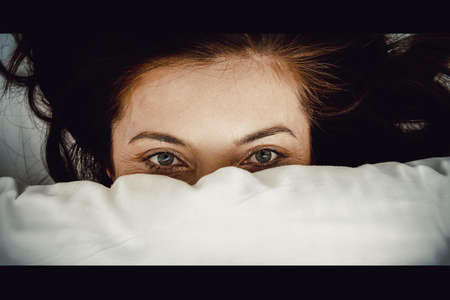 Scared woman in bed.の写真素材