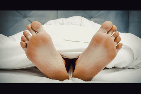 Bare womans feet in bedroom.