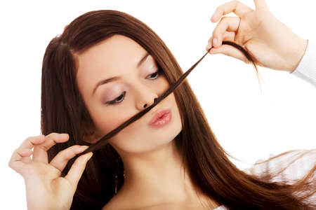 Funny student woman putting hair like moustacheの写真素材