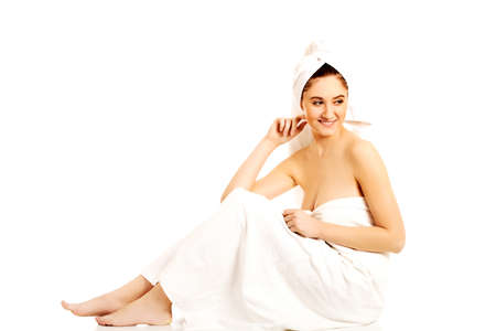 Young smile  woman wrapped towels sittingの写真素材