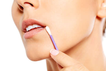 Young woman putting ear stick into mouth.の写真素材