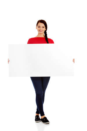 Beautiful young woman holding a blank bannerの写真素材
