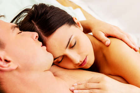 Beautiful young couple lying in bed.の写真素材