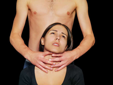 Home violence - young woman is choked by mans handの写真素材