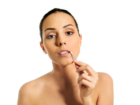 Young woman putting ear stick into mouthの写真素材