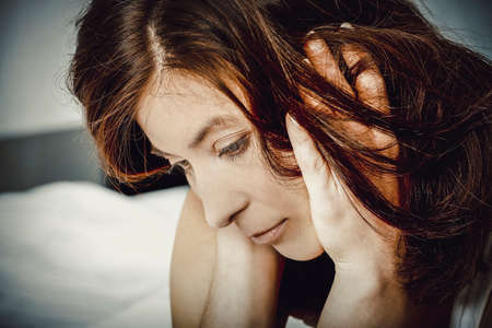 Sad depressed woman on bed.の写真素材