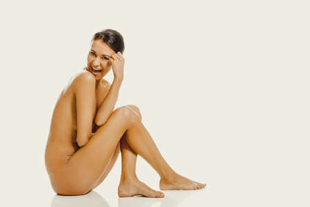 Nude woman sitting and looking downの写真素材