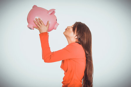 Happy woman kissing her piggy bank.の写真素材