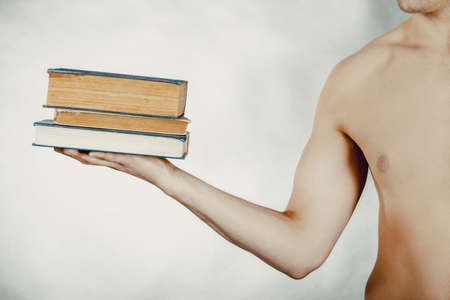 Young man holding stack of books.の写真素材