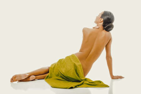 Back view woman sitting wrapped in towelの写真素材