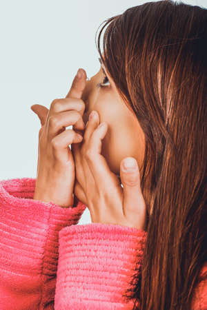 Woman putting contact lens in her eye.の写真素材