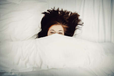 Scared woman in bed.の写真素材