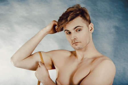 Young man measuring biceps.の写真素材