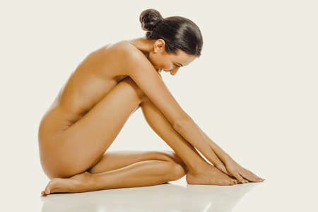 Spa woman sitting touching her footの写真素材